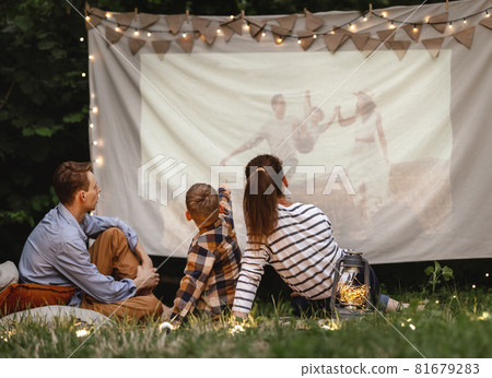 Family watching film in garden 81679283