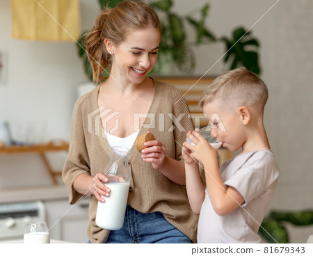 Mother pouring milk for son 81679343