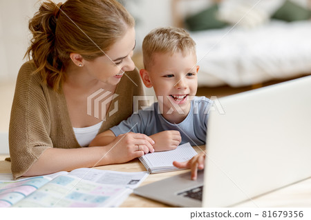 Happy mother supporting son during online studies Happy mother supporting son during online studies 81679356
