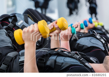 Group of people in wireless ems gym exercising with weight Group of people in wireless ems gym exercising with weight 81680201