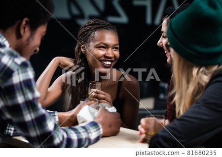 Multi ethnic people enjoying evening drinks 81680235