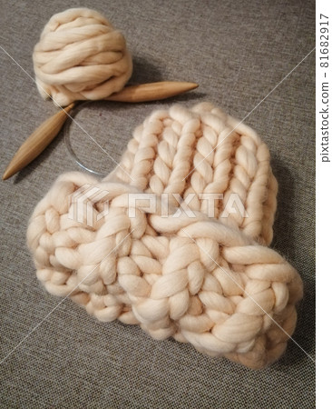 Hat made of sheep wool of large knitting. With a ball of yarn and wooden spokes. 81682917