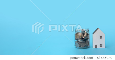 Money coin in glass jar and mini house on blue background with copy space, prepare money for new house, family plan, home, loan, money investment concept. 81683980
