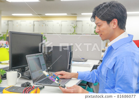 A smiling electric engineer holding the board with his left hand 1 A smiling electric engineer holding the board with his left hand 1 81686077