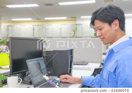A smiling electric engineer holding the board with his left hand 2 A smiling electric engineer holding the board with his left hand 2 81686078