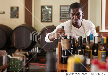 Winemaker arranging bottles in wine shop Winemaker arranging bottles in wine shop 81686147