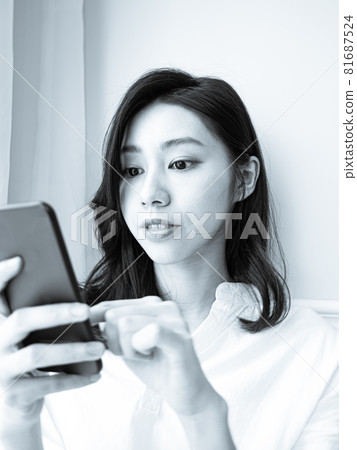 年輕的亞洲女性在家裡使用智慧型手機 81687524