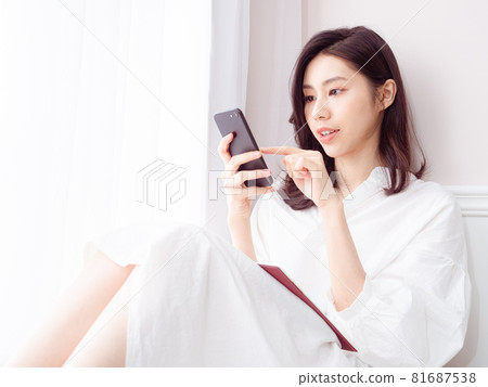 Young Asian woman using smartphone at home 81687538