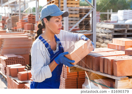 Female builder working in outdoor storage 81690379