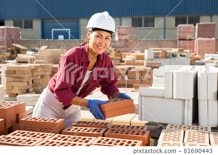 Asian worker stacking bricks in warehouse of building materials on an open-air site Asian worker stacking bricks in warehouse of building materials on an open-air site 81690443