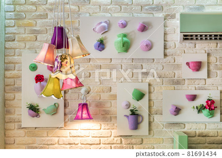 Bunch of pendant lamps against brick wall with decorative panels Bunch of pendant lamps against brick wall with decorative panels 81691434