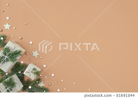 Christmas gift boxes and fir tree on beige background Christmas gift boxes and fir tree on beige background 81691844
