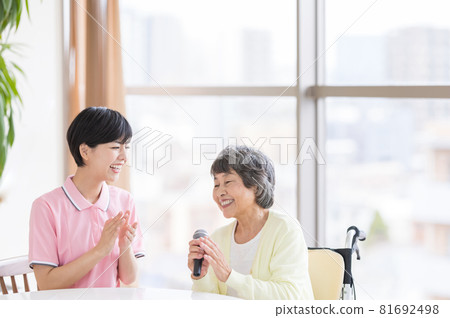 護理場景 休閒卡拉OK 老年婦女和護理人員用話筒熱情唱歌 護理場景 休閒卡拉OK 老年婦女和護理人員用話筒熱情唱歌 81692498