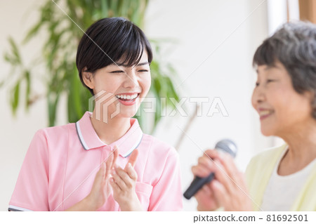 Nursing care scene Recreation Karaoke Senior women and caregivers singing enthusiastically with a microphone 81692501