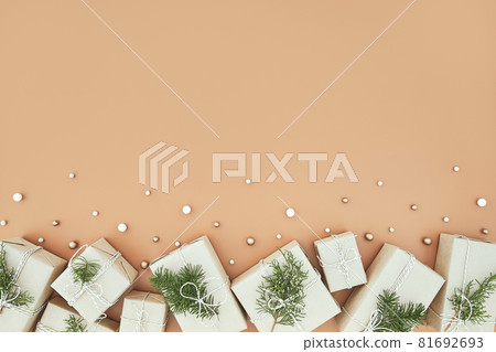 Christmas gift boxes and fir tree on beige background Christmas gift boxes and fir tree on beige background 81692693