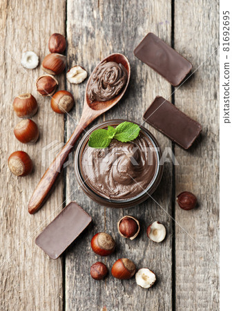 Chocolate cream with filbert nuts on wooden backgrounds. Chocolate cream with filbert nuts on wooden backgrounds. 81692695