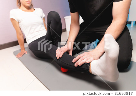 Physiotherapist teaches self-massage with red balls, patient with leg injury. Treatment of sports injuries. Practical use. Rehabilitation concept. Physiotherapist teaches self-massage with red balls, patient with leg injury. Treatment of sports injuries. Practical use. Rehabilitation concept. 81693817