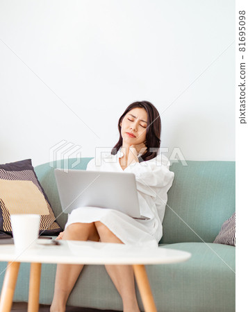Young Asian woman feels uncomfortable while using laptop 81695098