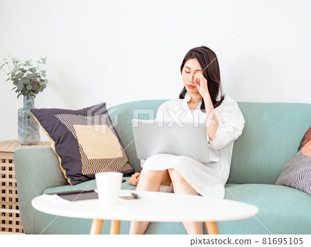 Young Asian woman feels uncomfortable while using laptop Young Asian woman feels uncomfortable while using laptop 81695105