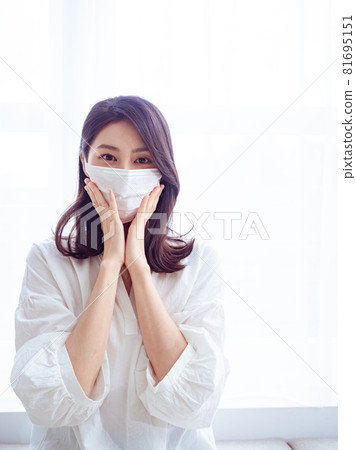Young Asian woman suffering from flu wearing surgical mask at home 81695151