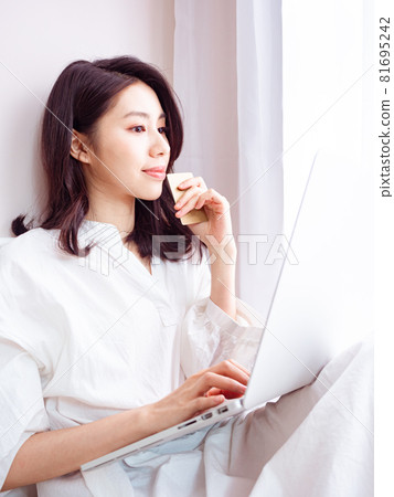 亞洲最美麗的女人可以使用書寫電子設備進行線上購物,使用信用卡進行電子支付。 亞洲最美麗的女人可以使用書寫電子設備進行線上購物,使用信用卡進行電子支付。 81695242