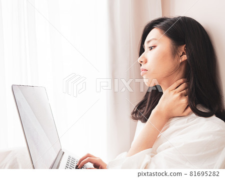 Young Asian woman feeling shoulder pain while using laptop Young Asian woman feeling shoulder pain while using laptop 81695282