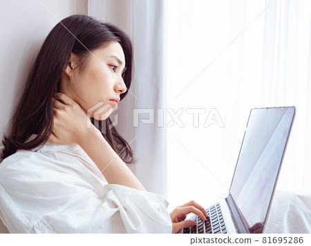 亞洲年輕女性使用筆記本電腦時感覺肩部疼痛 亞洲年輕女性使用筆記本電腦時感覺肩部疼痛 81695286