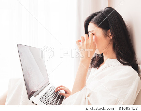 在亞洲，該女學生目前正在使用書寫式電子設備，這是用疲憊的眼睛書寫的。 81695418