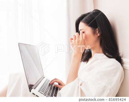 在亞洲，該女學生目前正在使用書寫式電子設備，這是用疲憊的眼睛書寫的。 81695424