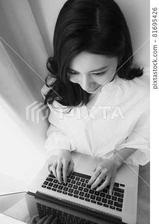 Young Asian woman using laptop at home 81695426
