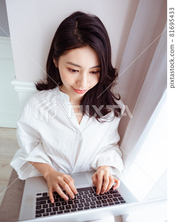 年輕亞裔女性在家使用筆記型電腦 81695433
