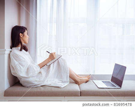 一位美麗的亞洲年輕女性在書中寫下一些東西 一位美麗的亞洲年輕女性在書中寫下一些東西 81695478