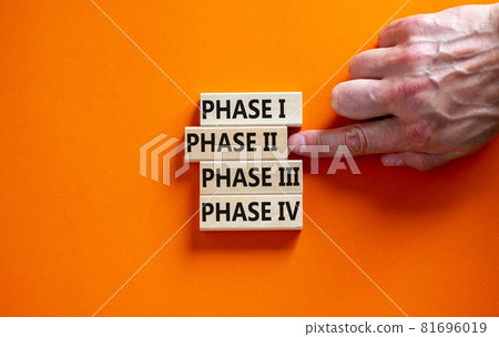 Time to phase 2. Wooden blocks form the words 'phase, 1, 2, 3, 4' on orange background. Male hand. Beautiful background. Business and covid-19 vaccine trial concept. Time to phase 2. Wooden blocks form the words 'phase, 1, 2, 3, 4' on orange background. Male hand. Beautiful background. Business and covid-19 vaccine trial concept. 81696019