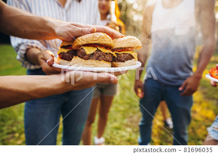 Croped image of picninc food preparation. Friends cooiking outside Croped image of picninc food preparation. Friends cooiking outside 81696035