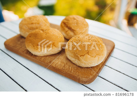 Tasty image of burger buns laying on cutting board Tasty image of burger buns laying on cutting board 81696178