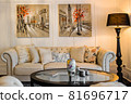 Big and comfortable living room with bright sofa and paintings on the walls 81696717