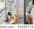 Candles and orchid flowers on the table in bathroom, pregnant belly in the mirror 81696719
