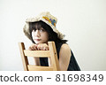 Portrait of a woman wearing a straw hat 81698349