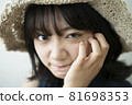 Portrait of a woman wearing a straw hat 81698353