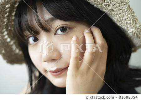 Portrait of a woman wearing a straw hat Portrait of a woman wearing a straw hat 81698354