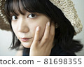 Portrait of a woman wearing a straw hat 81698355