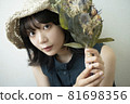 Portrait of a woman wearing a straw hat 81698356