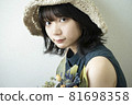 Portrait of a woman wearing a straw hat 81698358