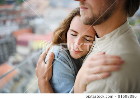 Happy young couple in love standing outdoors on balcony at home, hugging. 81698886