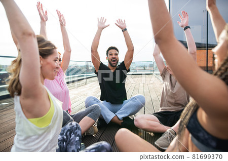 Group of young people doing exercise outdoors on terrace, sport and healthy lifestyle concept. 81699370
