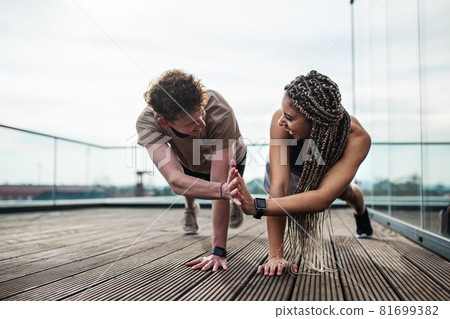Young couple doing exercise outdoors on terrace, sport and healthy lifestyle concept. Young couple doing exercise outdoors on terrace, sport and healthy lifestyle concept. 81699382