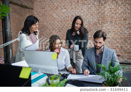 Young and old businesspeople sitting and working at desk in office, cooperation concept. 81699411