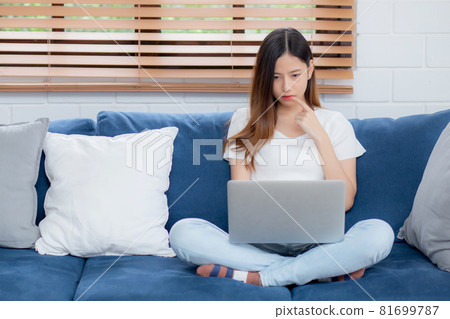 Beautiful young asian woman working on laptop computer and thinking idea on sofa at home. Beautiful young asian woman working on laptop computer and thinking idea on sofa at home. 81699787