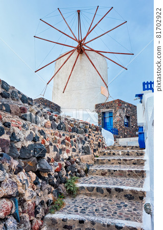 Old greek windmill on Santorini island in Oia town with stairs in street. Santorini, Greece 81702922
