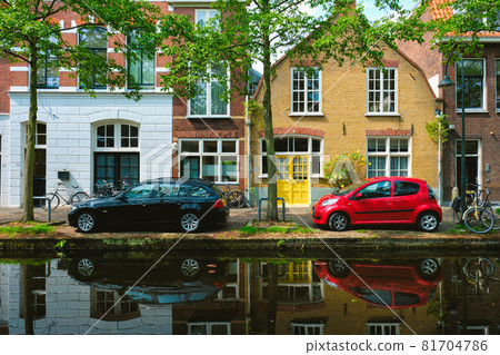 Cars on canal embankment in street of Delft. Delft, Netherlands 81704786